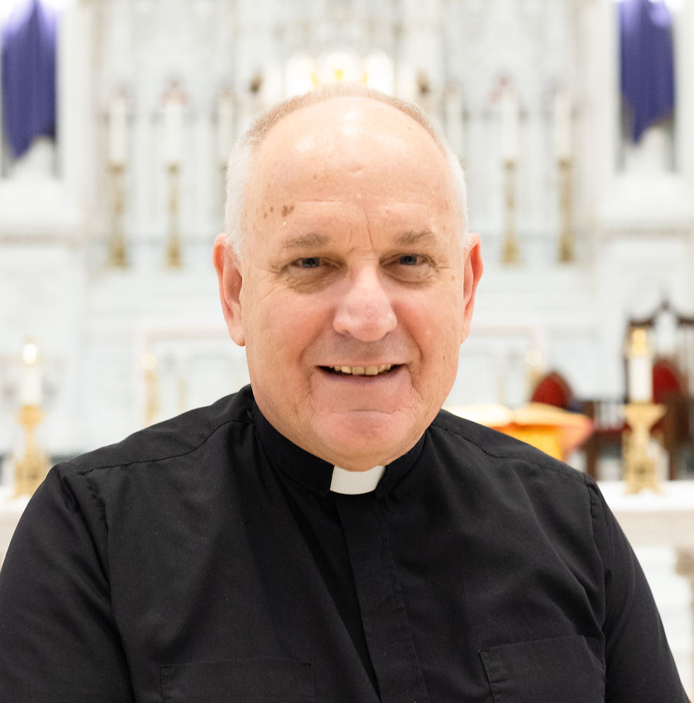 A priest in a green cassock smiling